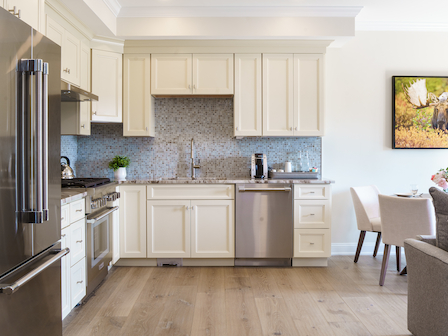 Modern kitchen with stainless steel appliances and white cabinets.